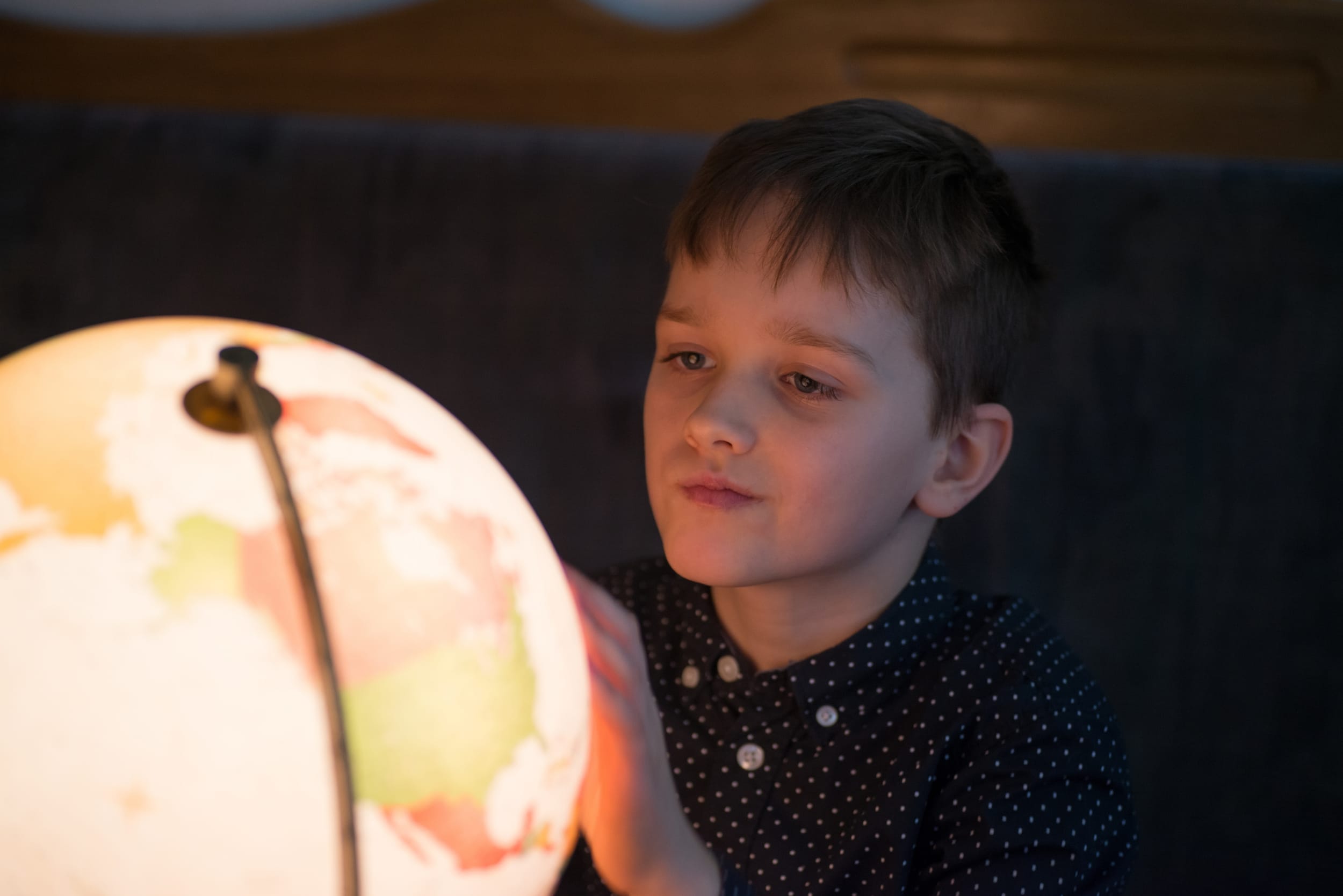 Gutt som ser på globus